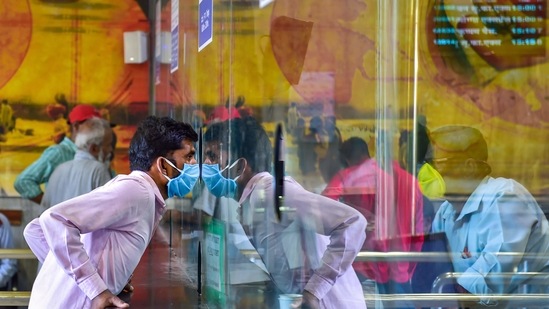 A passenger, wearing a mask in the wake of coronavirus (Covid-19) pandemic, speaks to a railway official at an enquiry counter, at Bengaluru City Railway Station, Monday, March 16, 2020. (PTI)