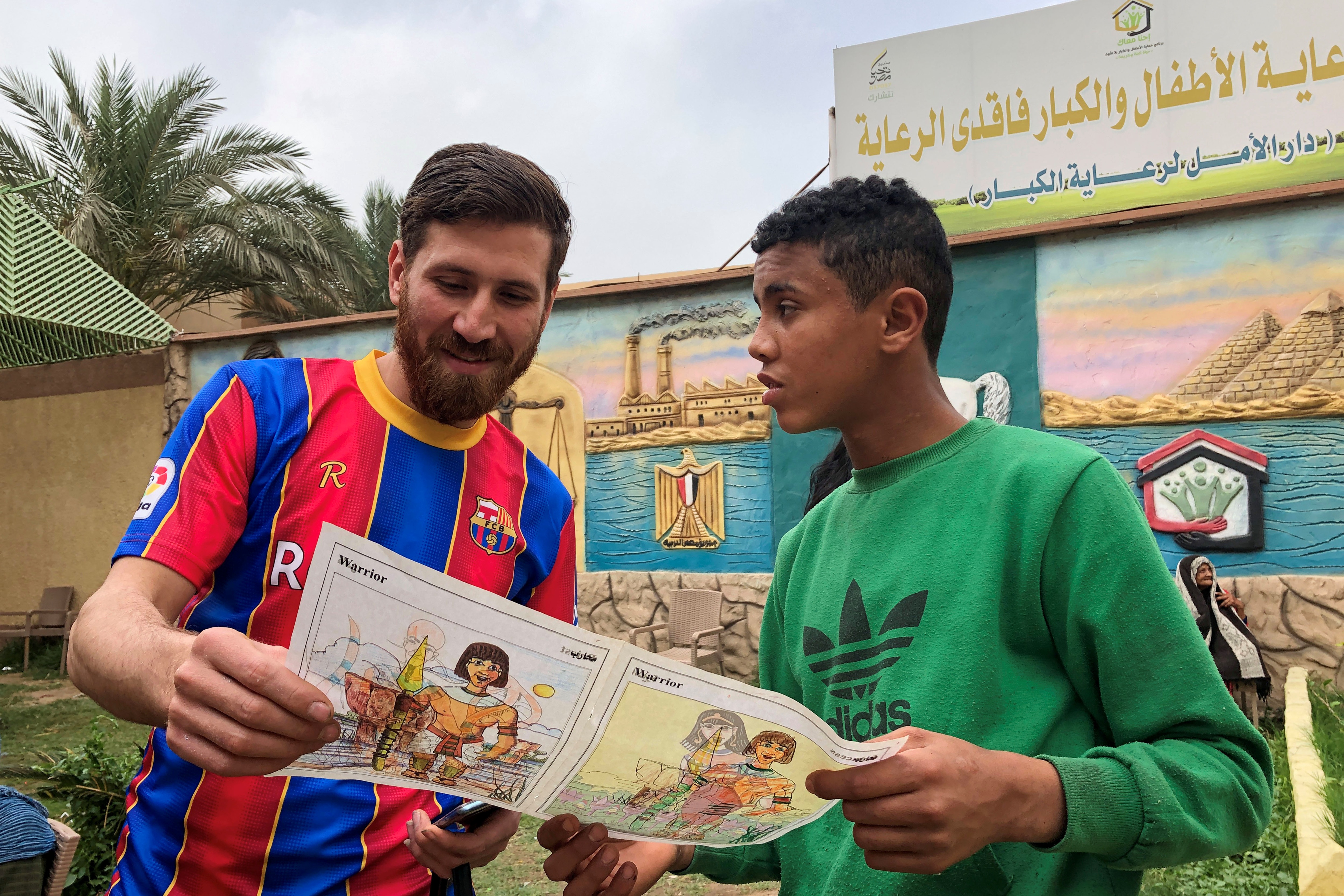 Islam Mohammed Ibrahim Battah, an Egyptian with a striking resemblance to BarcelonaÕs forward Lionel Messi, is seen with a youth in a club training facility,(REUTERS)