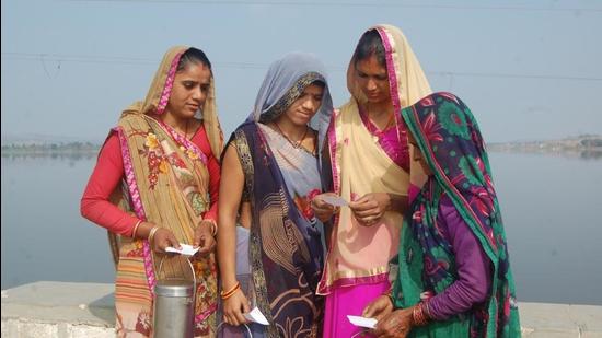 Balinee’s women milk producers checking their receipts for the milk they gave to the procurement centre. (HT Photo) Balinee’s women milk producers checking their receipts for the milk they gave to the procurement centre. (HT Photo)