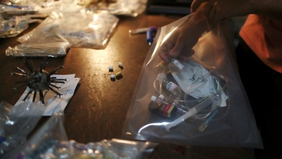 Facundo Mineldin, assistant to Argentine artist Marcelo Toledo (not pictured), arranges a bag with empty vials of the coronavirus disease (COVID-19) vaccines, and other medical supplies that will be part of the "Museum of the After", at Toledo's workshop in Buenos Aires, Argentina March 4, 2021. (REUTERS)