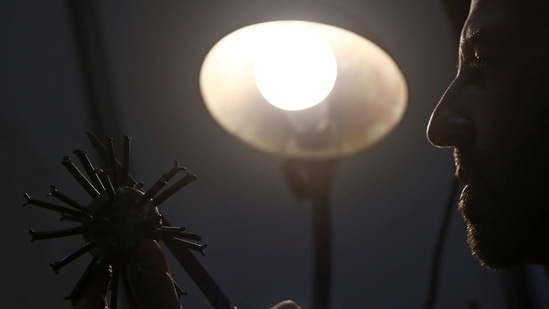 Argentine artist Marcelo Toledo works on an art piece depicting a coronavirus virion made from iron that will be part of the "Museum of the After", at his workshop in Buenos Aires, Argentina March 4, 2021. Picture taken March 4, 2021. REUTERS/Agustin Marcarian(REUTERS)