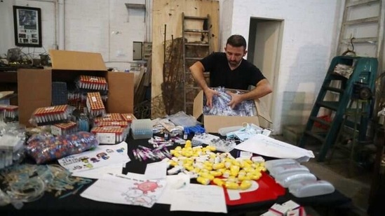Argentine artist Marcelo Toledo opens a box with syringes that will be part of the "Museum of the After", at his workshop in Buenos Aires, Argentina March 4, 2021. (REUTERS)