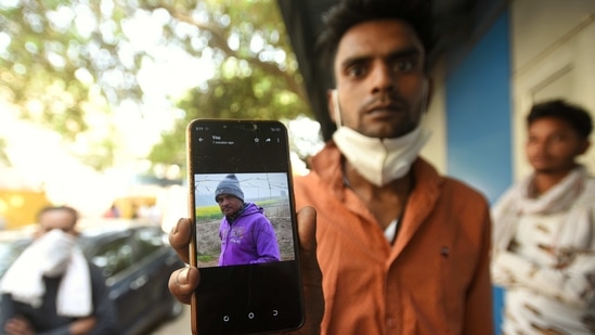 New Delhi, India - March 26, 2021: A relative showing a picture of Premchand, who died inside a manhole while cleaning the septic tank at Grand Emperor Banquet Hall, in Ghazipur, New Delhi, India, on Friday, March 26, 2021. Two people died in the incident. (Photo by Amal KS / Hindustan Times)