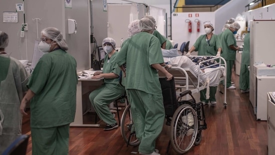 Healthcare workers treat Covid-19 patients inside a field hospital at the Pedro Dell'Antonia sports complex in Santo Andre, Brazil. (Bloomberg) Healthcare workers treat Covid-19 patients inside a field hospital at the Pedro Dell'Antonia sports complex in Santo Andre, Brazil. (Bloomberg)