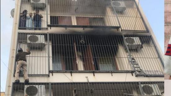 Policemen climb the grilles of a house in GK where a fire broke out on the second floor. (Sourced)