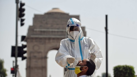 A healthcare worker collects the swab sample for Covid-19 testing from a person at India Gate in New Delhi. (ANI Photo)