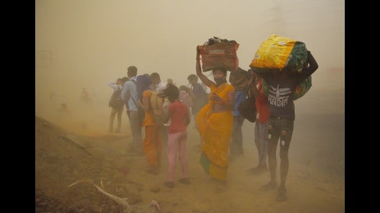 Migrant workers walking towards Farrukhabad and Sultanpur pause during a sudden dust storm, Ghaziabad, May 10, 2020. (Ajay Aggarwal /HT PHOTO)