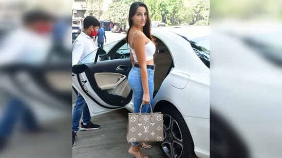 During her recent salon visit in Mumbai, Nora Fatehi was seen wearing a white spaghetti strap bodycon crop top.(Varinder Chawla)