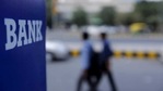 Commuters walk past a bank sign along a road in New Delhi.(Reuters File Photo) Commuters walk past a bank sign along a road in New Delhi.(Reuters File Photo)