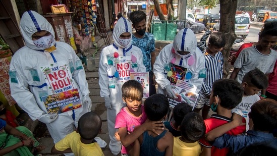 Mumbai, India - March 27, 2021: Members of Sion Friends Circle Wearing PPE suits distribute pamphlets amongst residents of Dharavi during awareness campaign on Not to Celebrate Holi this year amid coronavirus pandemic in Mumbai, India, on Saturday, March 27, 2021. (Photo by Pratik Chorge/Hindustan Times) (Pratik Chorge/HT Photo) Mumbai, India - March 27, 2021: Members of Sion Friends Circle Wearing PPE suits distribute pamphlets amongst residents of Dharavi during awareness campaign on Not to Celebrate Holi this year amid coronavirus pandemic in Mumbai, India, on Saturday, March 27, 2021. (Photo by Pratik Chorge/Hindustan Times) (Pratik Chorge/HT Photo)