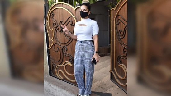 Sunny teamed her outfit with a pair of monochrome slides and a black face mask. The actor tied her hair in a top knot for her day out.(Varinder Chawla)