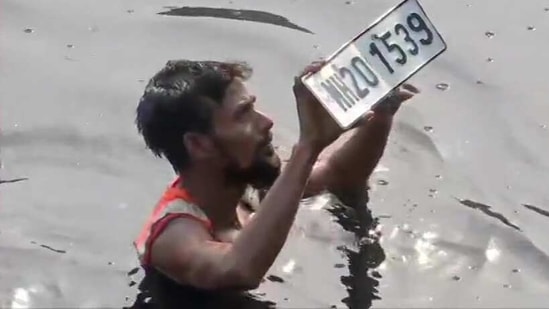 A diver fishes out a number plate from the Mithi river in Mumbai on Sunday. (ANI) A diver fishes out a number plate from the Mithi river in Mumbai on Sunday. (ANI)