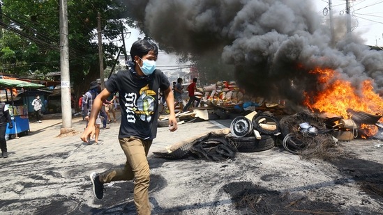 Anti-coup protesters run around their makeshift barricade they burn to make defense line during a demonstration in Yangon, Myanmar. (AP) Anti-coup protesters run around their makeshift barricade they burn to make defense line during a demonstration in Yangon, Myanmar. (AP)