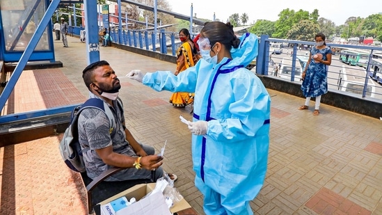 A health worker takes a swab sample from a man for the Covid-19 test, at Kempegowda bus stand in Bengaluru on Friday.(PTI)