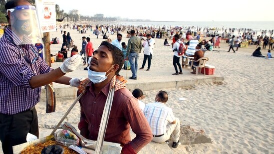 A medic takes a sample from a vendor for Covid-19 test at the Juhu beach in Mumbai on Saturday.(PTI Photo)