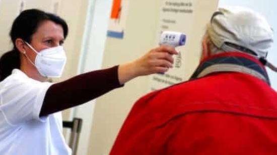 Medical staff takes the temperature of an elderly man arriving at a local vaccination centre as the spread of the coronavirus disease (Covid-19) continues in Ebersberg near Munich, Germany.(AP file photo)