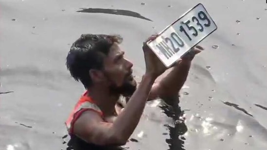 A diver showing the number plate found in Mithi River (ANI Twitter)