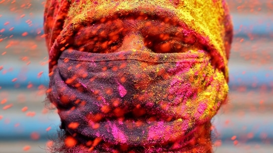 A man wearing a protective face mask reacts as colour powder is thrown towards him during Holi celebrations, amidst the spread of the coronavirus disease (COVID-19), in Chennai, India, March 29, 2021.  (REUTERS)