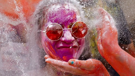 A woman reacts as colour powder is applied to her face on during Holi celebrations, amidst the spread of the coronavirus disease (COVID-19), in Ahmedabad, India, March 29, 2021. (REUTERS)