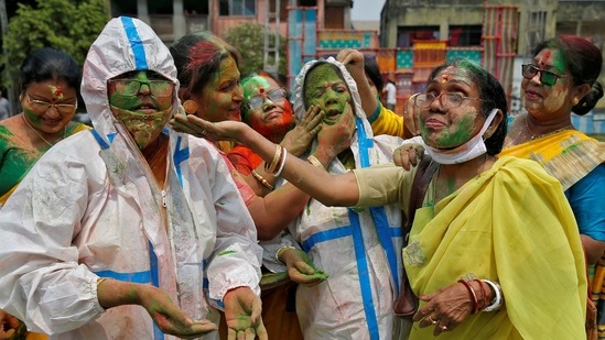 Women wearing protective suits react as coloured powder is applied on their faces Holi celebrations, amidst the spread of the coronavirus disease (COVID-19), in Kolkata, India, March 29, 2021.  (REUTERS)