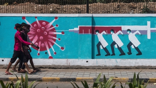 People walk past a wall mural depicting medical staff as frontline Covid-19 warriors in Mumbai on Monday. (Pratik Chorge/HT Photo)