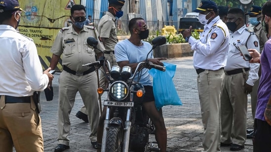 Police personnel stopping a motorist at a checkpoint during restrictions imposed around Holi as Covid-19 coronavirus cases rise, in Mumbai on March 29. Police personnel stopping a motorist at a checkpoint during restrictions imposed around Holi as Covid-19 coronavirus cases rise, in Mumbai on March 29.
