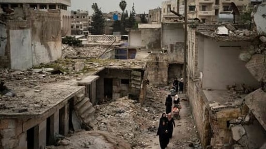 FILE - In this March 12, 2020 file photo, women walk in a neighborhood heavily damaged by airstrikes in Idlib, Syria. The humanitarian situation across war-ravaged Syria is worsening. But it’s been getting tougher every year to raise money from global donors to help people affected by the country’s protracted humanitarian crisis. The aid community is bracing for significant shortfalls ahead of a donor conference that starts Monday, March 29, 2021, in Brussels. (AP Photo/Felipe Dana, File)(AP) FILE - In this March 12, 2020 file photo, women walk in a neighborhood heavily damaged by airstrikes in Idlib, Syria. The humanitarian situation across war-ravaged Syria is worsening. But it’s been getting tougher every year to raise money from global donors to help people affected by the country’s protracted humanitarian crisis. The aid community is bracing for significant shortfalls ahead of a donor conference that starts Monday, March 29, 2021, in Brussels. (AP Photo/Felipe Dana, File)(AP)