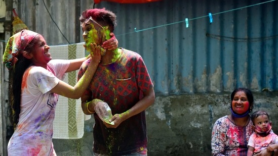 People celebrating Holi with coloured gulal powders, at Prabhadevi in Mumbai on March 29. Despite the restrictions, revellers still gathered in neighbourhoods across the country, banging drums and hurling coloured powder at each other.(Anshuman Poyrekar/HT Photo)