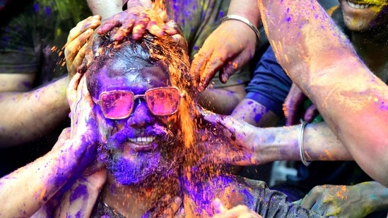 People celebrating Holi with coloured gulal powders, at Prabhadevi in Mumbai on March 29. Covid-19 cases are also rising in the capital New Delhi and states of Punjab, Karnataka, Gujarat, Tamil Nadu, Haryana and Madhya Pradesh.(Anshuman Poyrekar/HT Photo)