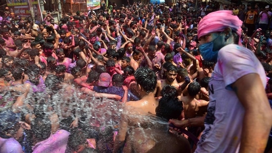 Revellers dance as they celebrate Holi, the spring festival of colours, in Allahabad on March 29, 2021. (AFP)