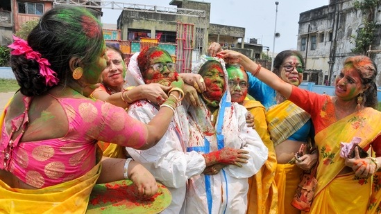Kolkata: Women, wearing PPE kit, play with dry colours during Holi festival, as coronavirus cases spike across the country, at Begumbazar in Kolkata, Monday, March 29, 2021.(PTI)