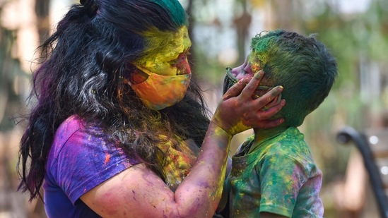 Mumbai: A woman smears colours to a child during celebration of 'Holi' festival amid spike in COVID-19 cases, in Mumbai, Monday, March 29, 2021. (PTI) Mumbai: A woman smears colours to a child during celebration of 'Holi' festival amid spike in COVID-19 cases, in Mumbai, Monday, March 29, 2021. (PTI)
