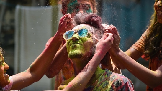 Mumbai: People smear dry colours on each other during 'Holi' festival, amid a spike in coronavirus cases, in Mumbai, Monday, March 29, 2021. (PTI) Mumbai: People smear dry colours on each other during 'Holi' festival, amid a spike in coronavirus cases, in Mumbai, Monday, March 29, 2021. (PTI)