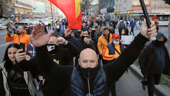 The new restrictions include an 8pm curfew and, in hard-hit areas, shorter shopping hours. In picture - Protests in downtown Bucharest.(AP)