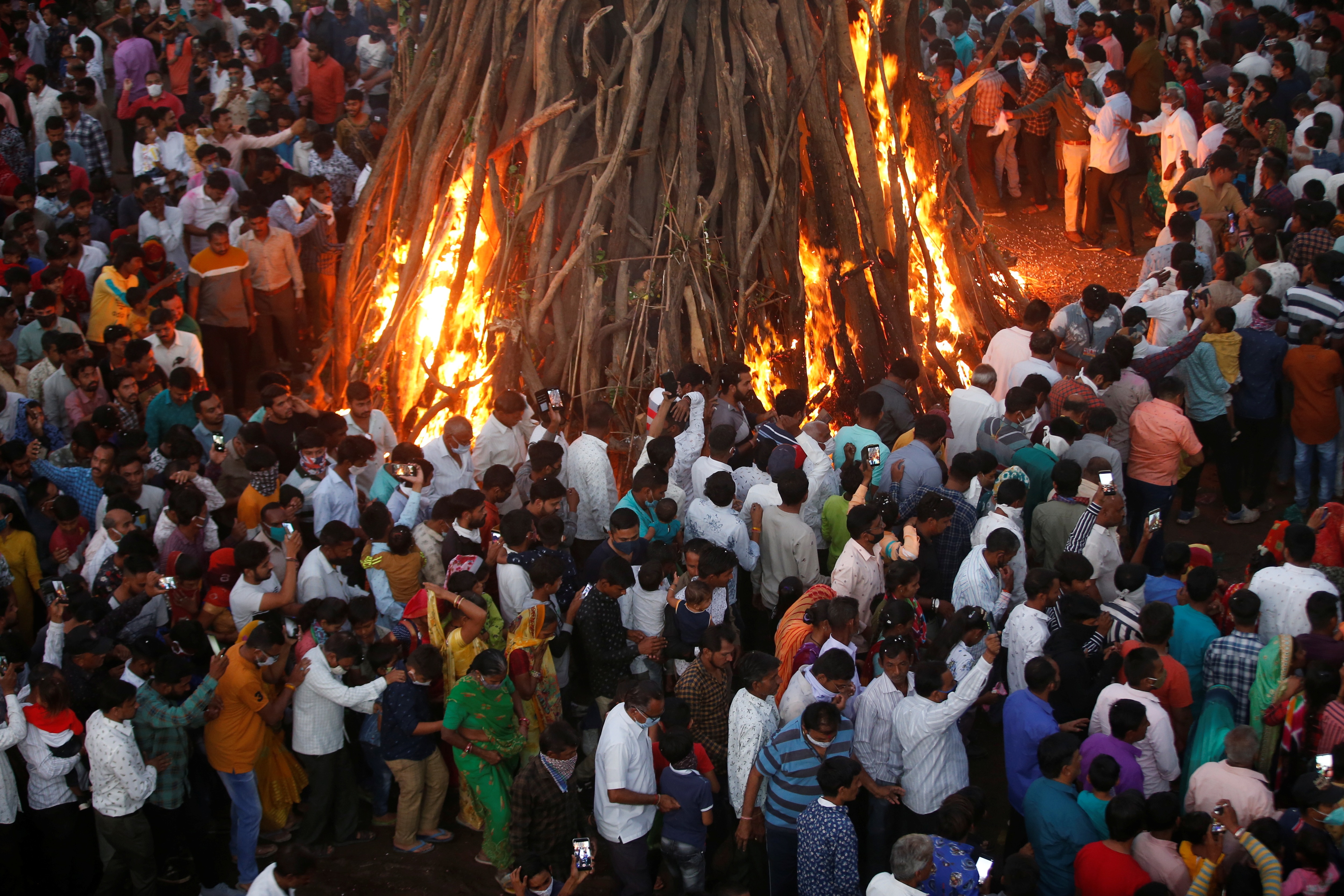 Hindu devotees walk around a bonfire during a ritual known as "Holika Dahan" which is part of the Holi festival celebrations, amidst the spread of the coronavirus disease (COVID-19), in Ahmedabad, India, March 28, 2021. REUTERS/Amit Dave (REUTERS)