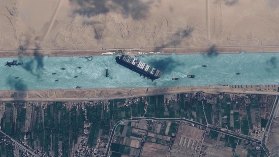 An aerial view of the MV Ever Given container ship and tugboats in the Suez Canal on March 29. The MV Ever Given was refloated and the Suez Canal reopened on March 29, sparking relief almost a week after the huge container ship got stuck during a sandstorm and blocked a major artery for global trade.(Maxar Technologies / AFP)