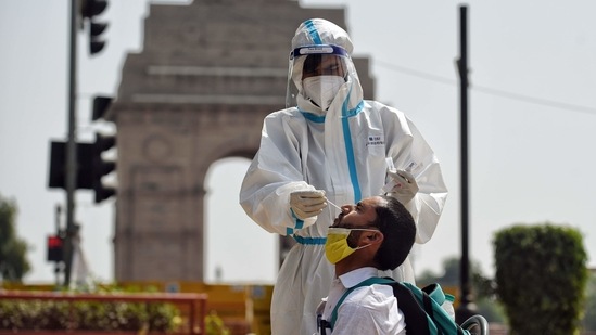 A healthcare worker collects the swab sample for Covid-19 testing from a person at India Gate in New Delhi. (ANI) A healthcare worker collects the swab sample for Covid-19 testing from a person at India Gate in New Delhi. (ANI)