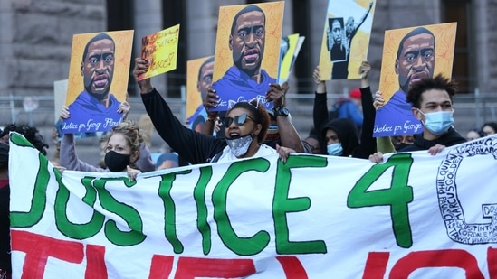 Demonstrators hold images of George Floyd during a protest outside the Hennepin County Government Center in Minneapolis, Minnesota, US(Bloomberg)