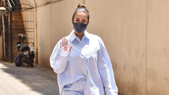 Malaika Arora in white shirt, waving to the photographers. Malaika Arora in white shirt, waving to the photographers.