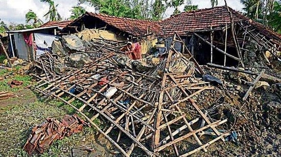 A woman tries to gather her belongings from her damaged house in Kakdwip, Sunderbans.(HT Photo)