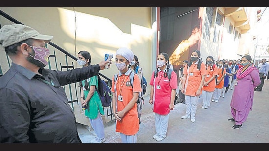 Students undergoing thermal screening as they arrive to attend classes on the opening day of new academic session, at a school in Jammu, Wednesday. (PTI) Students undergoing thermal screening as they arrive to attend classes on the opening day of new academic session, at a school in Jammu, Wednesday. (PTI)