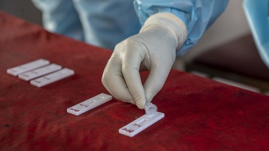 A health worker tests a swab sample for Covid-19 infection, in Srinagar, on March 30. The number of active cases in India went up by 11,846, and currently stand at 5,52,566, health ministry's data showed.(Dar Yasin / AP)