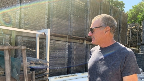 Australian oyster farmer and co-owner of Harpers Oysters, Brett Harper, stands in his oyster shed yard near oyster trays after raging floodwaters decimated his business, in Dunbogan, Australia. (Reuters)