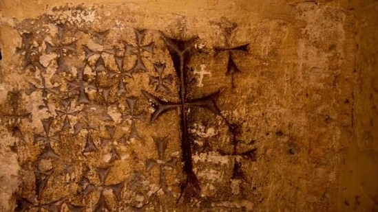 Crosses etched into the ancient stone wall of the Saint Helena chapel are seen inside the Church of the Holy Sepulchre which is revered in Christian tradition as the site of Jesus' crucifixion and burial, in Jerusalem's Old City February 24, 2021. (REUTERS)