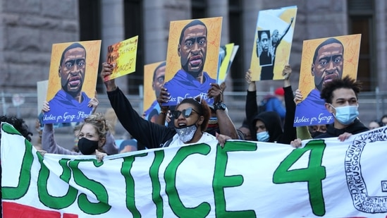 Demonstrators hold images of George Floyd during a protest outside the Hennepin County Government Center in Minneapolis, Minnesota, US(Bloomberg)