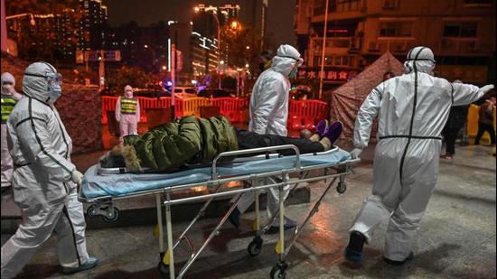 In this photo taken on January 25, 2020 medical staff wearing protective clothing to help stop the spread of a deadly virus which began in the city, arrive with a patient at the Wuhan Red Cross Hospital in China. (AFP)