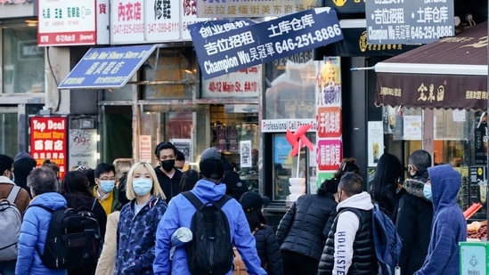 Pedestrians walk in the Flushing neighbourhood in the Queens borough of New York, Tuesday, March 30, 2021.(AP)