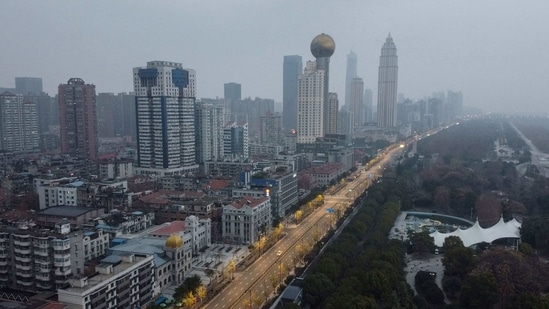 (FILES) In this file photo taken on January 27, 2020 an aerial view shows residential and commercial buildings of Wuhan in China's central Hubei province, amid a deadly virus outbreak which began in the city. - An international expert mission to Wuhan has concluded that it was very likely that Covid first passed to humans from a bat through an intermediary animal, while all but ruling out a lab incident. The experts said that the intermediary host hypothesis was deemed "likely to very likely", while the theory that the virus escaped from a laboratory was seen as "extremely unlikely", according to the final version of the long-awaited report, of which AFP obtained a copy on March 29, 2021 before the official release. (Photo by Hector RETAMAL / AFP) (AFP) (FILES) In this file photo taken on January 27, 2020 an aerial view shows residential and commercial buildings of Wuhan in China's central Hubei province, amid a deadly virus outbreak which began in the city. - An international expert mission to Wuhan has concluded that it was very likely that Covid first passed to humans from a bat through an intermediary animal, while all but ruling out a lab incident. The experts said that the intermediary host hypothesis was deemed "likely to very likely", while the theory that the virus escaped from a laboratory was seen as "extremely unlikely", according to the final version of the long-awaited report, of which AFP obtained a copy on March 29, 2021 before the official release. (Photo by Hector RETAMAL / AFP) (AFP)