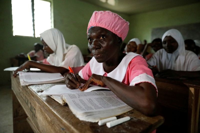 Shade Ajayi, 50, takes notes during class at Ilorin Grammar School in Ilorin, Kwara state. (REUTERS)