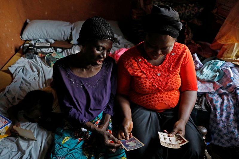 Shade Ajayi, 50, shows old photographs of herself to her daughter Shola Adeboye at her home in Ilorin, Kwara state, Nigeria. (REUTERS)